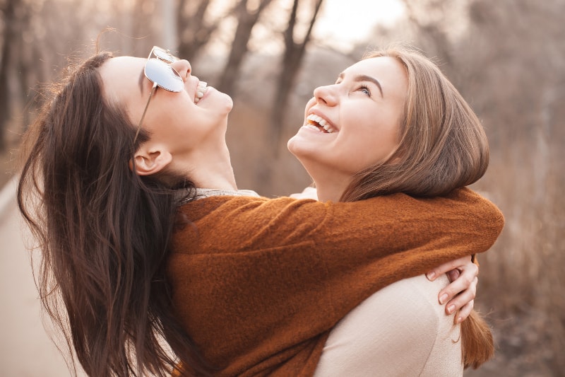 de jeunes amis heureux qui s'embrassent et lèvent les yeux
