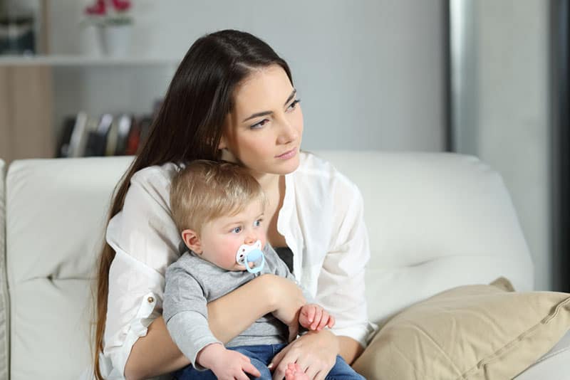 femme inquiète assise avec bébé sur ses genoux