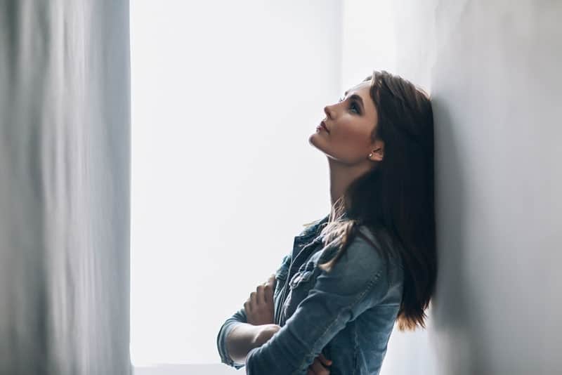femme inquiète debout près du mur