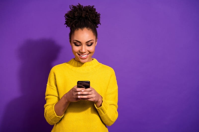 fille tenant le téléphone dans les mains et envoyer des SMS