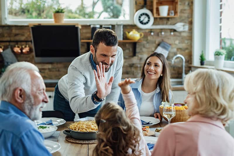 homme heureux, donner cinq à l'enfant pour le dîner