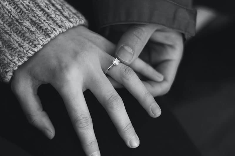 homme tenant la main de la femme avec bague de fiançailles dessus