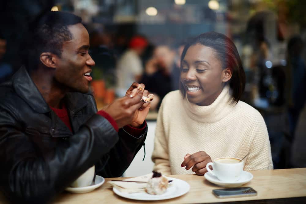 un homme est assis avec une femme et boit du café