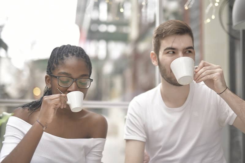 un homme et une femme buvant du café