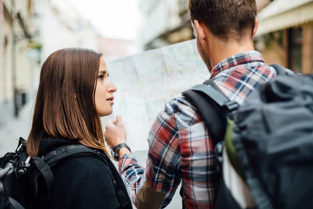 un homme et une femme marchent dans la rue une femme a l'air confuse à un homme