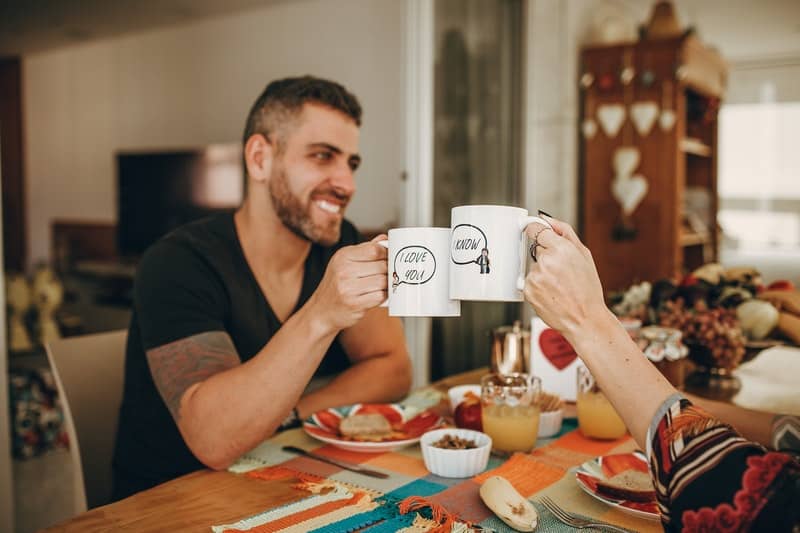 un homme et une femme s'assoient à une table et mangent
