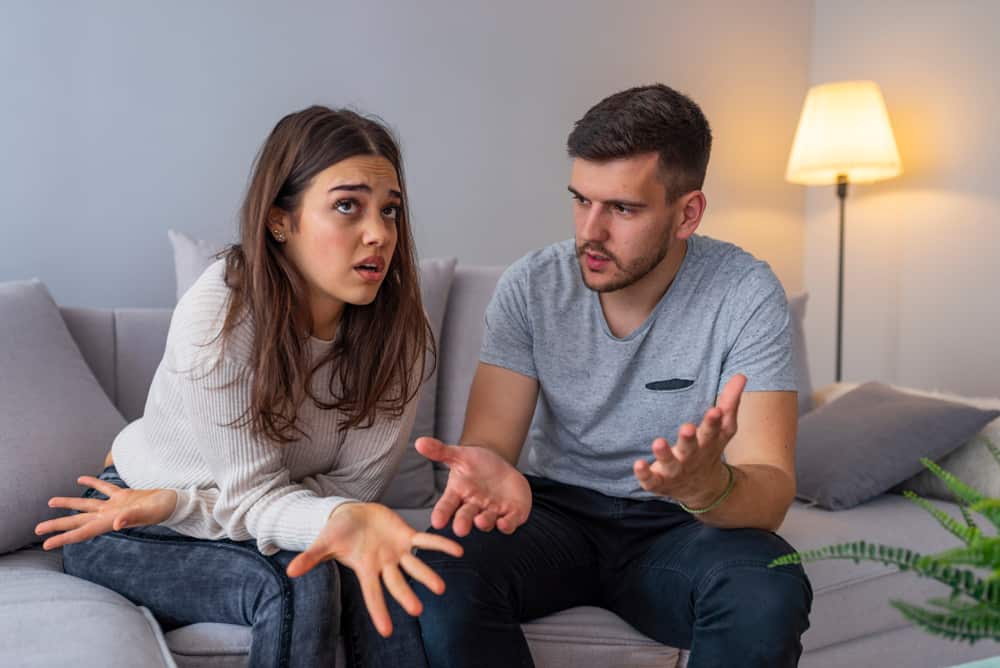un homme et une femme se disputent sur le canapé