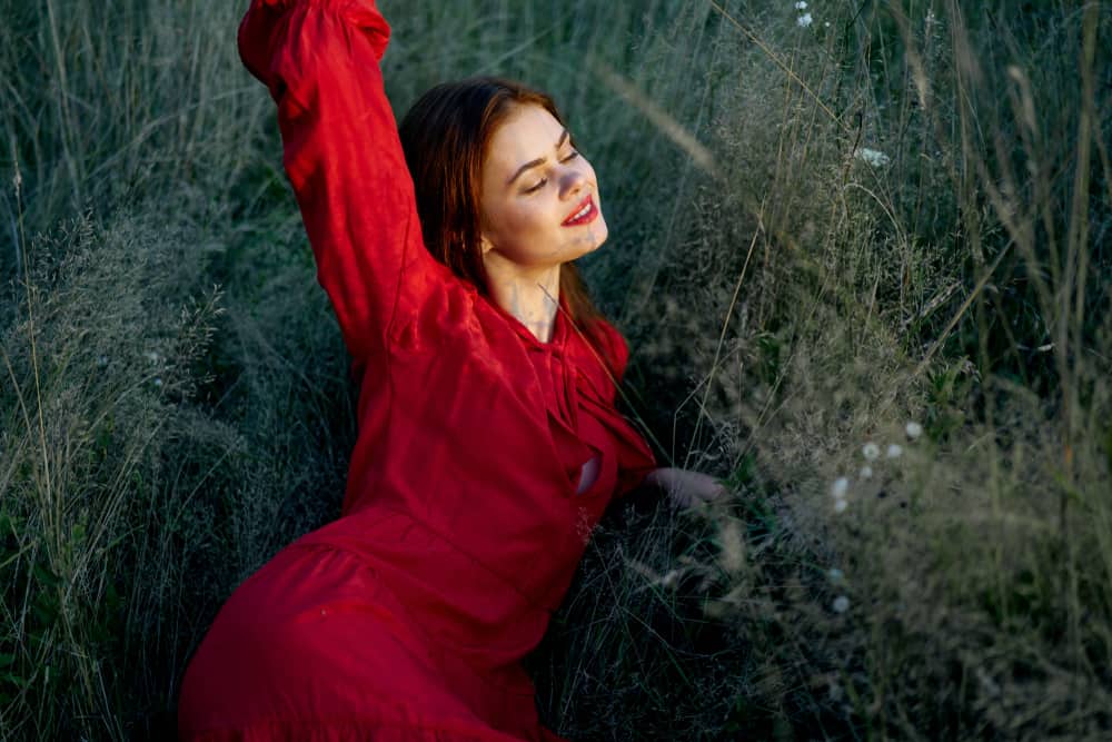 une femme en robe rouge se couche
