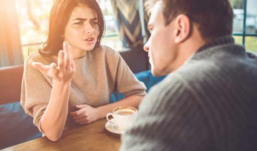 une femme et un homme se disputent a table