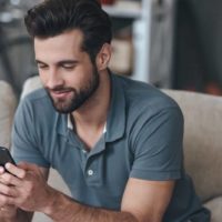 un homme est assis et touche au téléphone