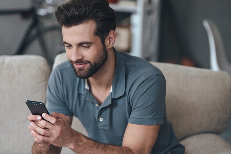 un homme est assis et touche au téléphone