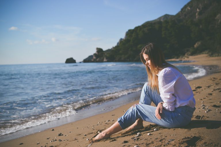une femme est assise sur une plage