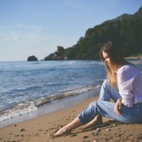 une femme est assise sur une plage