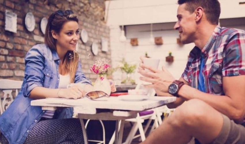 un homme et une femme assis a table et boivent du cafe