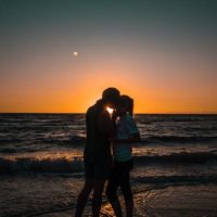 couple s'embrassant au coucher du soleil