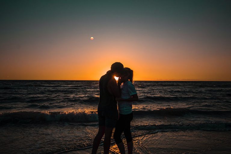 couple s'embrassant au coucher du soleil