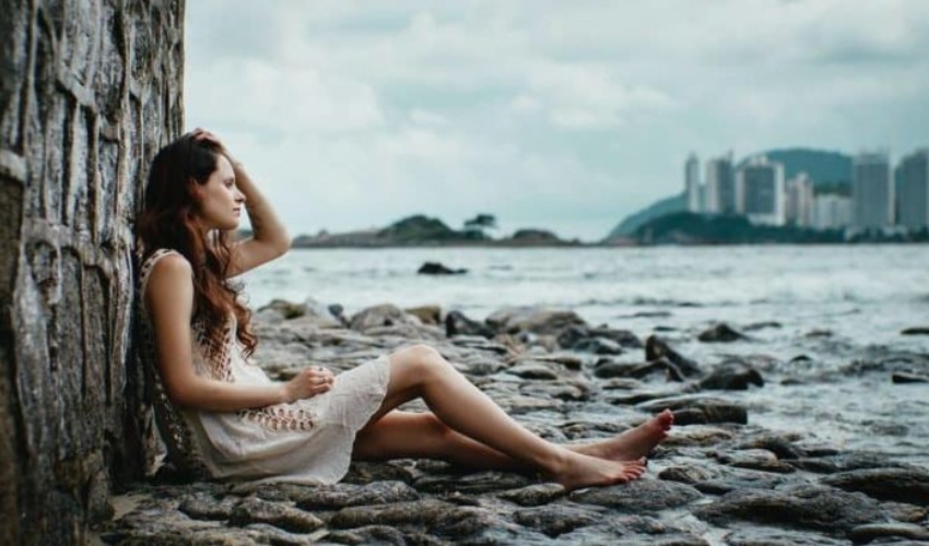 la femme assise appuyee contre un rocher