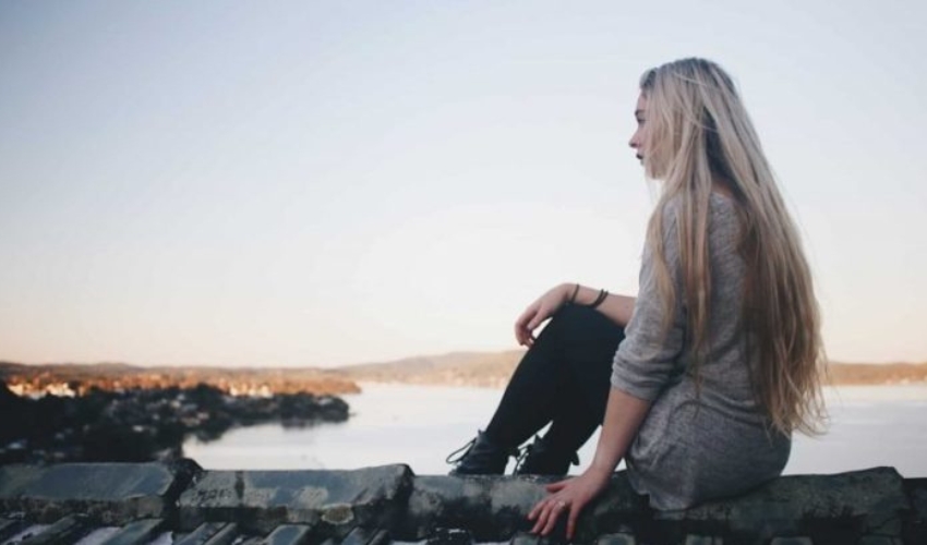 une femme aux longs cheveux blonds est assise sur le dos