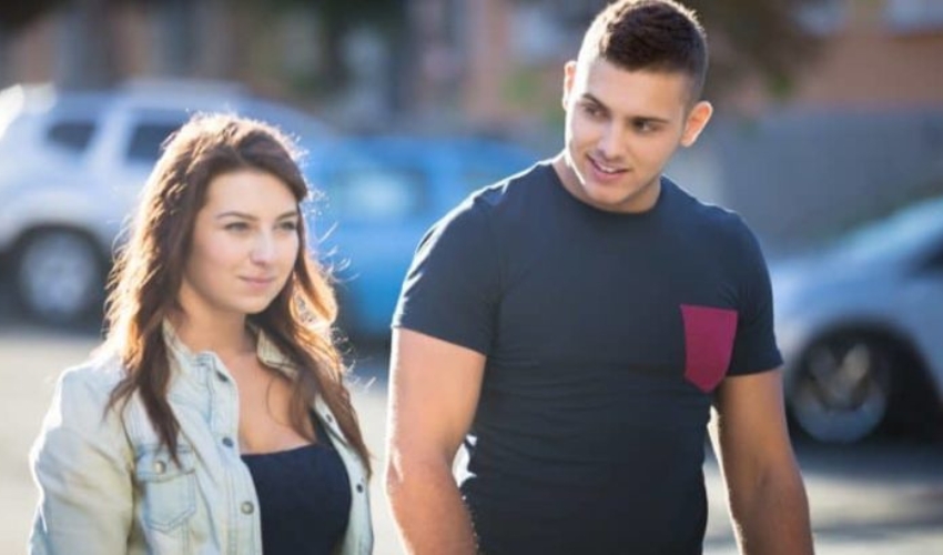 un homme et une femme marchent dans la rue