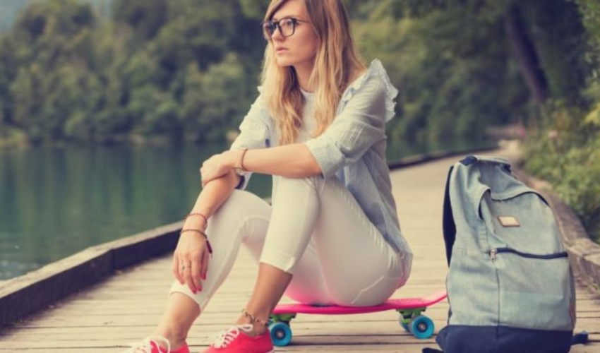 une femme imaginaire assise sur une planche a roulettes