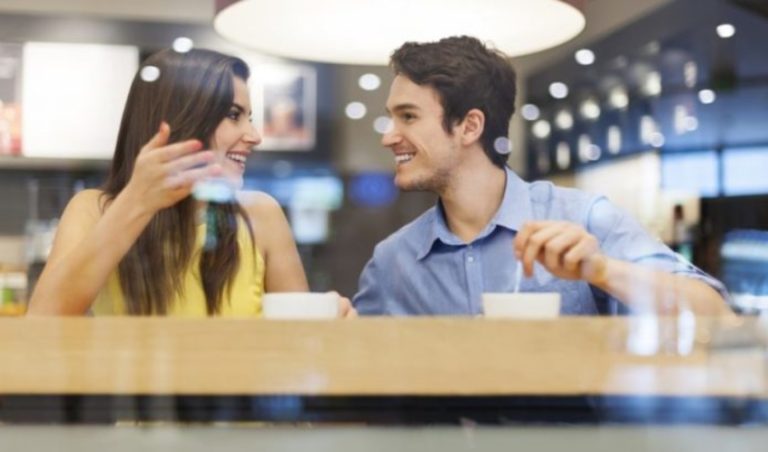 un homme et une femme sassoient a une table et parlent