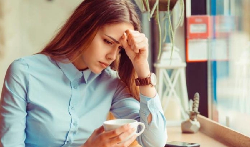 une femme decue sessoit et boit du cafe