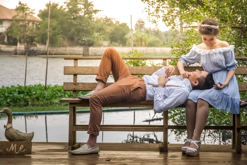 un beau jeune couple assis sur un banc et bénéficiant d'une caresse