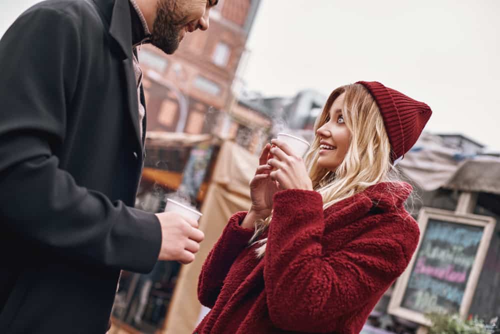 Un couple aimant souriant debout à l'extérieur et parlant