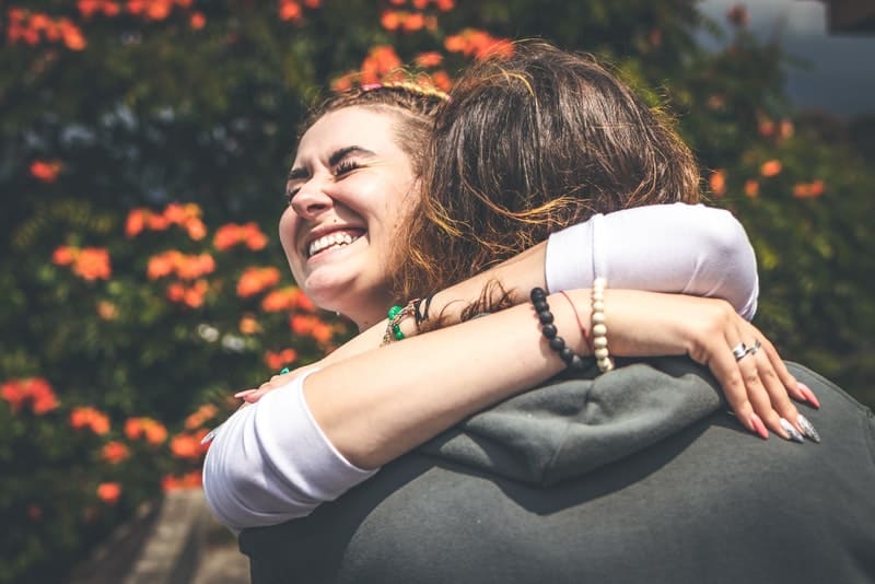 Un couple d'amoureux heureux debout à l'extérieur dans une étreinte