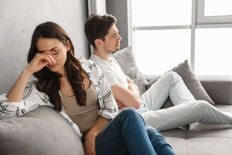 Un couple déçu, assis ensemble sur un canapé