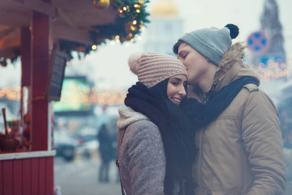 Un jeune couple aimant debout à l'extérieur dans une étreinte