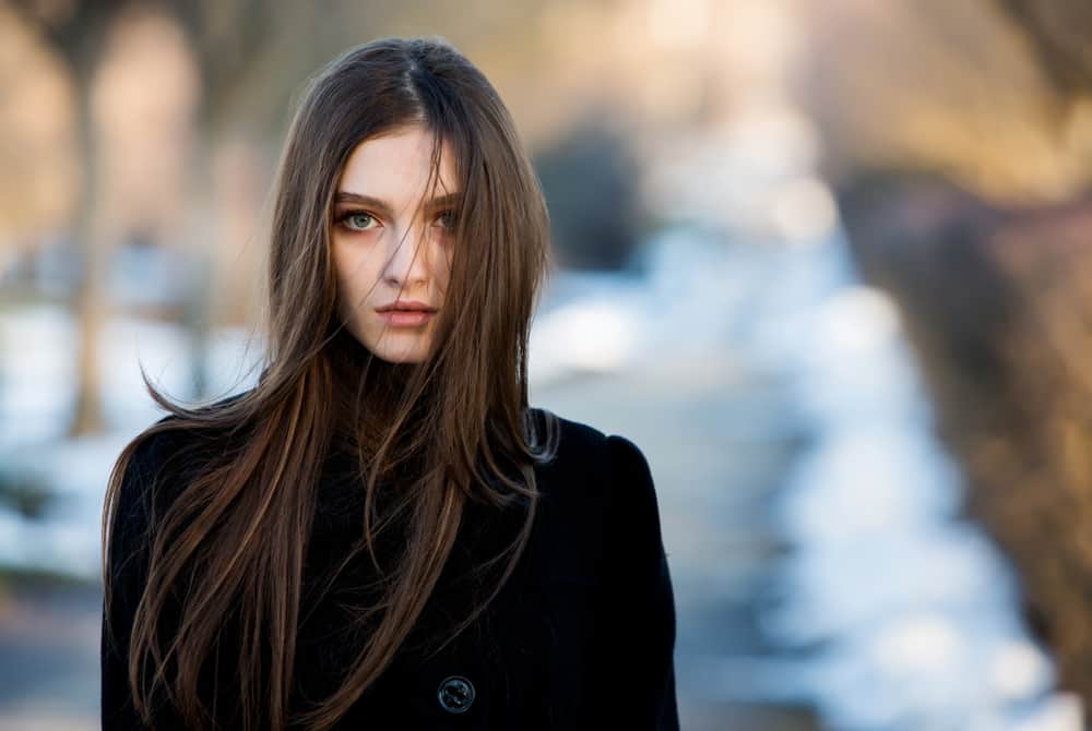 Une femme déçue marche dans la rue avec de longs cheveux noirs