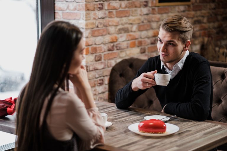 un homme et une femme s'assoient et boivent du café