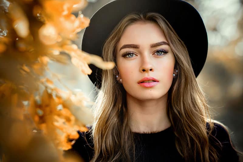 belle femme avec chapeau regardant la caméra