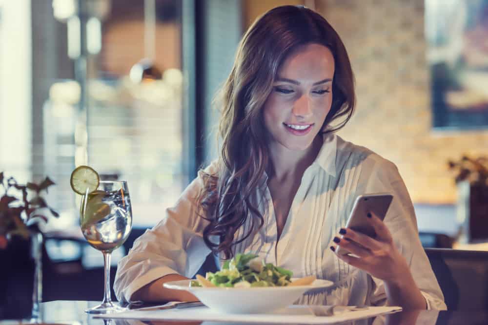 belle femme avec petit déjeuner écrit sms