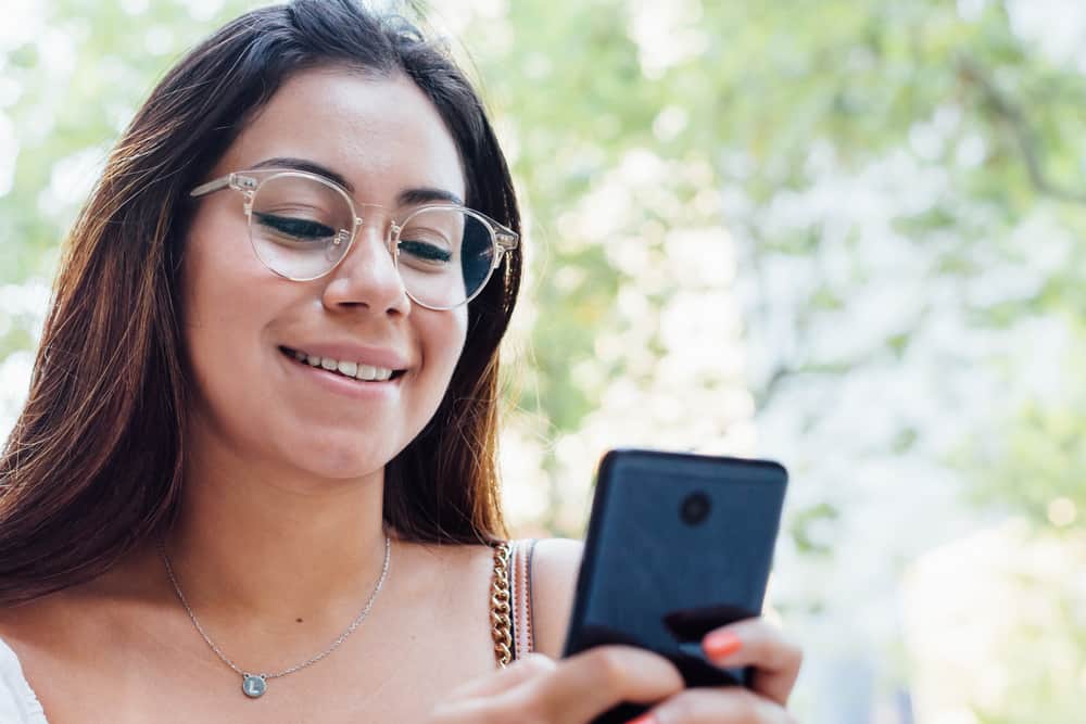 brune souriante écrit des sms