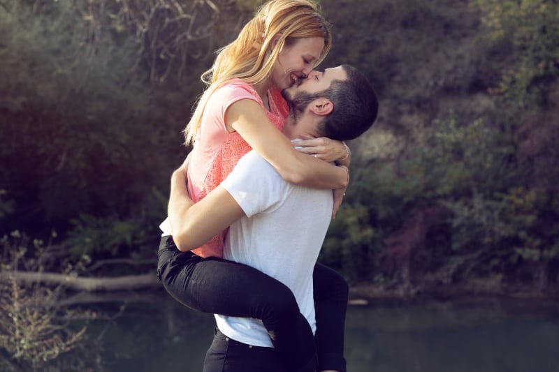 couple amoureux étreignant au bord du lac