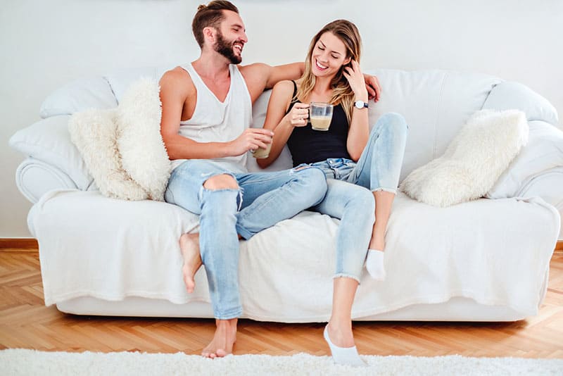couple heureux, parler sur le canapé