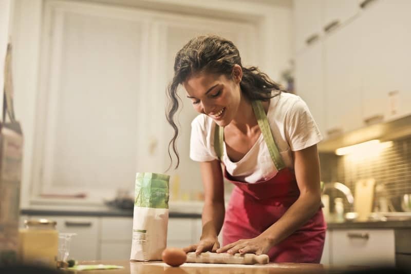 dans la cuisine, une femme souriante prépare le déjeuner