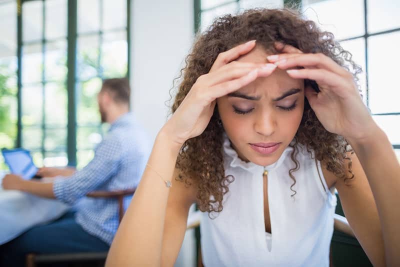 femme inquiète assise au restaurant