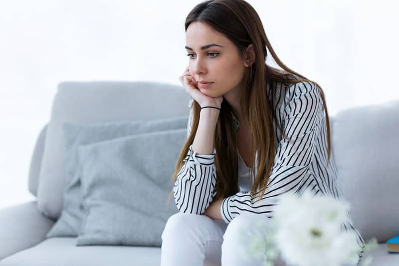 femme inquiète assise en pleine conscience sur le canapé