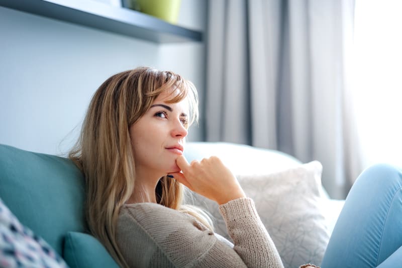fille assise sur le canapé et pensant