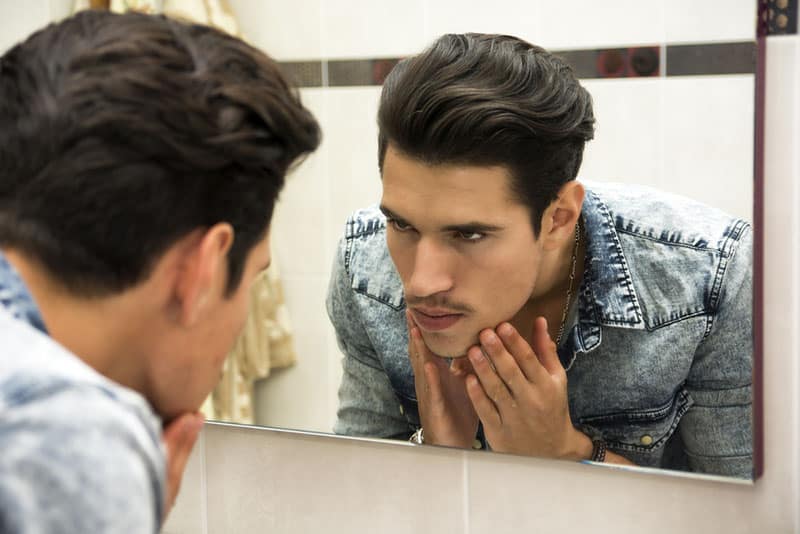 homme sérieux regardant miroir