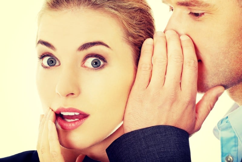 Des hommes chuchotant un secret à son ami surpris