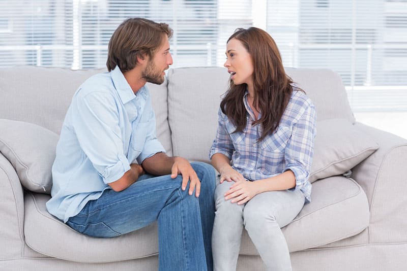 jeune couple parlant sur le canapé