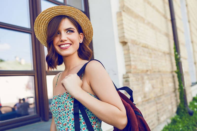 jolie femme souriante portant sac à dos