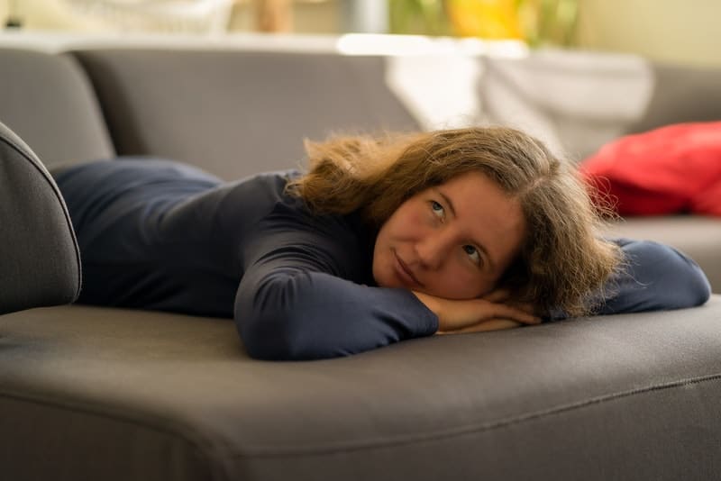 la femme est allongée sur le ventre sur le lit