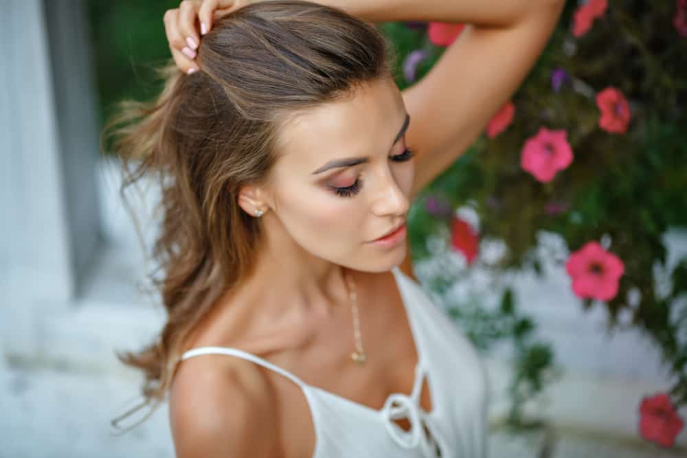 la femme lève ses cheveux avec sa main