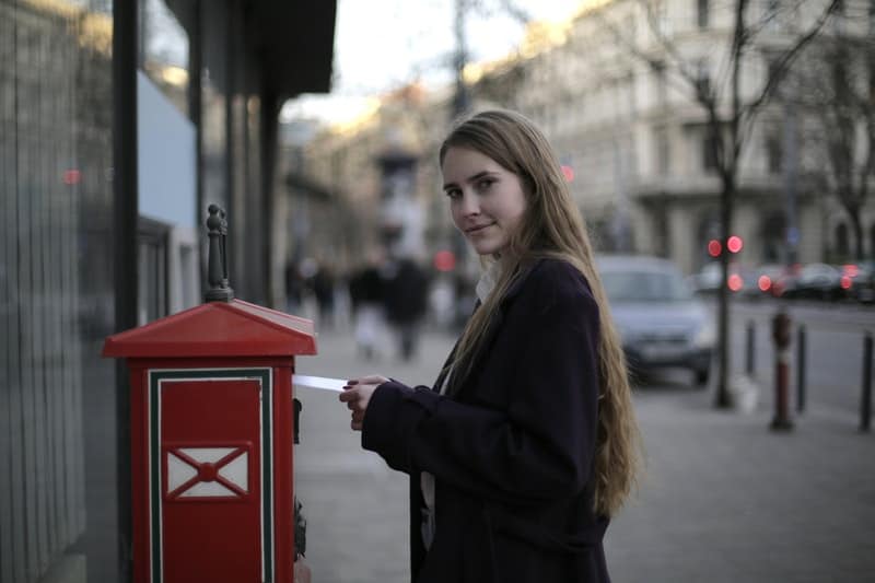 la femme met la lettre dans la boîte