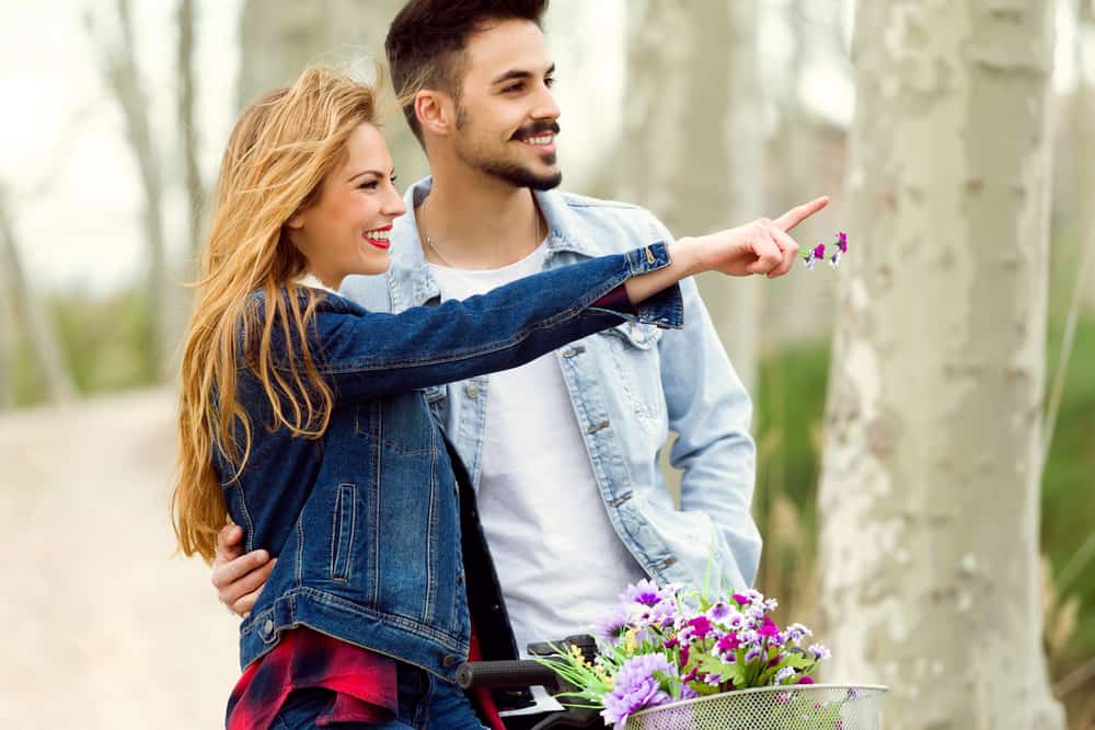 la femme montre du doigt quelque chose à l'homme dont il rit